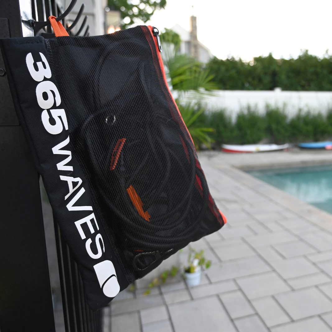 An image of the 365Waves Surf Resistance Training Kit bag hanging on a fence by a swimming pool