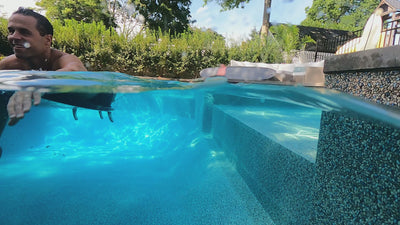 A video scanning across the waterline of people paddling on surfboards in a swimming pool using the 365Waves Resistance Surf Trainer